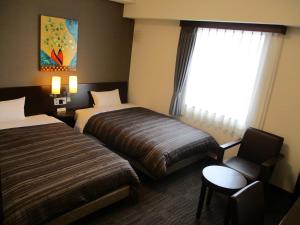 北九州鲁特因酒店 - 北九州市若松站东的酒店客房带两张床、椅子和窗户