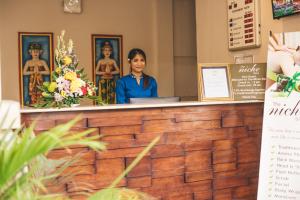 勒吉安尼诗巴厘岛酒店的女人站在房间里柜台后面