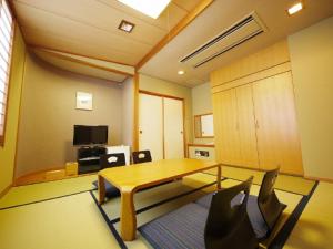 秩父市Hotel Route-Inn Seibu Chichibu Ekimae的客厅配有玻璃桌和椅子