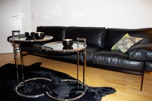 特里尔Casa Augusta - Urban Living的客厅配有两张桌子和一张沙发