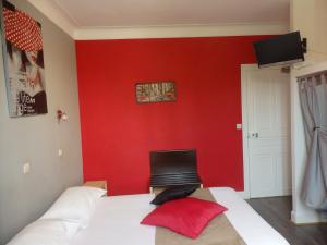 Blessacle relais des forêts的一间卧室设有红色的墙壁和一张带笔记本电脑的床