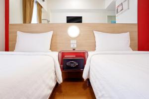 卡加盐德奥罗Red Planet Cagayan De Oro的两张床铺,房间装有红色的行李箱