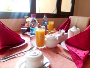 吉布提吉布提莱斯金合欢酒店的一张桌子,上面放着早餐食品和橙汁