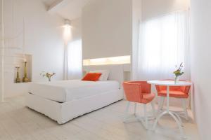 圣阿尔坎杰洛-迪罗马涅B&B Di Charme Le Contrade的白色的卧室配有白色的床和一张桌子