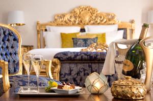 圣迈克桑莱科勒Hôtel Saint-Martin - La Maison Younan的一间卧室配有一张床和一张带香槟杯的桌子