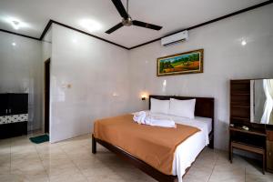蓝梦岛美格卡亚简易别墅旅馆的一间卧室配有一张床和吊扇