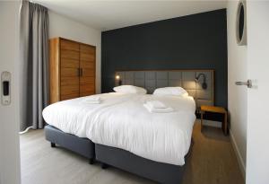 奥斯特豪特Landgoed Bergvliet的一间卧室配有一张带白色床单的大床
