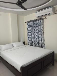 维沙卡帕特南Feel like home -Guest House near Tenneti park的一间卧室配有一张带吊扇的床