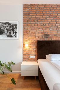 波兹南Cinema Apartments的卧室设有砖墙,毗邻一张床