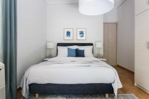 雅典Bright 2BD Apartment in Psychiko by UPSTREET的一间卧室配有一张带蓝色枕头的大床
