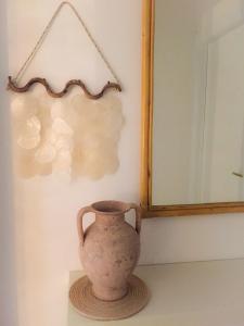 帕图Villa del mar的坐在镜子旁的桌子上的花瓶