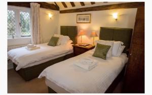 温莎The Old Farmhouse的带窗户的客房内设有两张单人床。