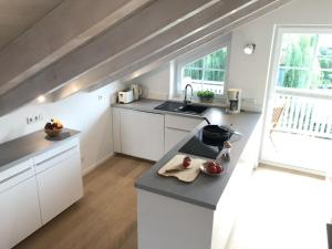 格拉绍Haus Vincent的厨房配有白色橱柜和台面