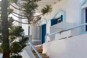 费马Ferma Hill Apartments的一条带有蓝色门和棕榈树的楼梯