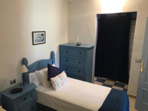 圣地亚哥海滩Apartamento El Cascajo的一间卧室配有蓝色的床和蓝色梳妆台