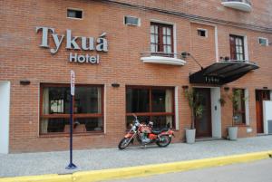 GualeguaychúHotel Tykua的停在砖楼前的摩托车