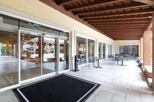 阿菲B&B Hotel Affi - Lago di Garda的一个带玻璃门和桌椅的庭院