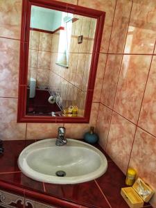 波斯托伊纳Odisey的浴室配有带镜子的盥洗盆和镜子