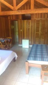 南蒙蒂阿莱格里Pousada Ypê das Montanhas的一间设有床铺和桌子的房间