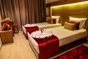 马拉喀什LE VOYAGEUR MARRAKECH的酒店客房 - 带两张带红色枕头的床