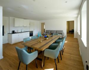 塔尔高Waldach Villa的一间带木桌和蓝色椅子的用餐室