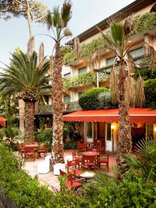 马尔米堡米尼翁酒店的拥有桌椅和棕榈树的酒店
