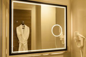 安卡拉Hm商务酒店的浴室镜子,壁架上装有白色浴袍