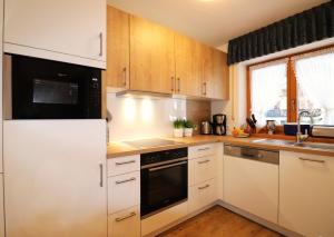奥伯斯特多夫Landhaus Am Schelmenhag 13a的厨房配有白色橱柜和炉灶烤箱。