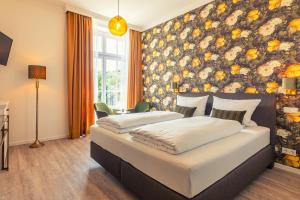 策尔廷根-拉蒂希Rochter Landhotel的卧室设有两张床铺和花卉墙