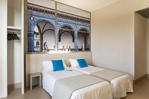 佛罗伦萨福罗伦萨诺弗豪华食宿酒店的一张位于一间客房的两张床,房间拥有一座建筑的壁画