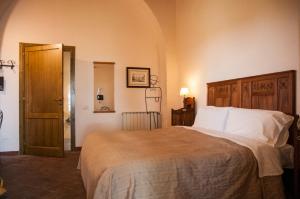 卡拉塔比亚诺Antico Borgo Etneo Agriturismo的卧室配有带白色枕头的大床