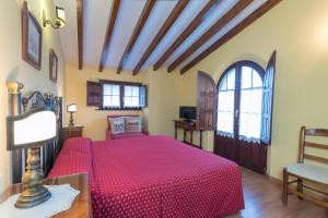 桑提亚纳德玛Posada de la Abadia - Adults Only的一间卧室配有一张红色床罩的床