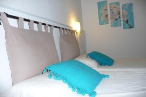 圣埃乌拉利亚耶比萨旅舍的一间卧室配有两张带蓝色枕头的床。