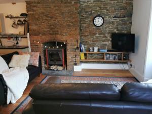 JacobstowTHE OLD RECTORY KIRKULLEN LOFT APARTMENT in Jacobstow 10 mins to Widemouth bay and Crackington Haven,15 mins Bude,20 mins tintagel, 27 mins Port Issac的带沙发和壁炉的客厅