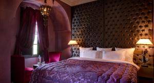 马拉喀什惊叹庭院旅馆的一间卧室配有一张大床和紫色床罩