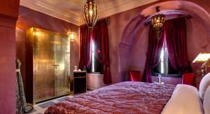马拉喀什惊叹庭院旅馆的一间卧室配有一张带红色窗帘的大床
