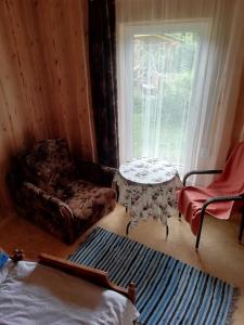 萨拉茨格里瓦Brīvdienu māja ar kopējo virtuvi的客房设有桌子、椅子和窗户。
