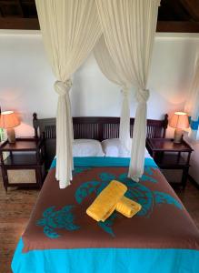 Afaahiti普纳提村庄酒店的一间卧室配有床,床上挂着窗帘和玉米