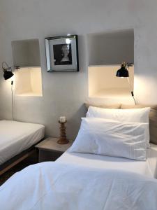 马丁纳弗兰卡Masseria Croce Piccola - Wineyard的一间卧室配有两张带白色床单和两张灯的卧室