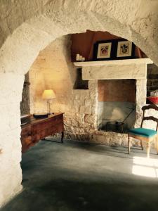 马丁纳弗兰卡Masseria Croce Piccola - Wineyard的客房设有带桌椅的石制壁炉。