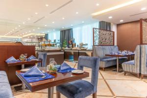 多哈多哈世纪大酒店的一间带桌椅的用餐室和一间酒吧