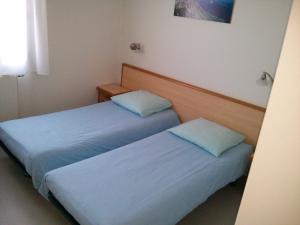 塔卢瓦尔弗洛里蒙塔纳酒店的小客房内的两张床,配有蓝色的床单