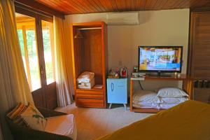 费尔南多 - 迪诺罗尼亚特里波旅馆的一间带电视和床的客厅
