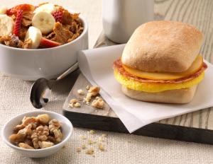 乔普林Home2 Suites By Hilton Joplin, MO的早餐三明治和一碗水果及坚果