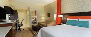 乔普林Home2 Suites By Hilton Joplin, MO的配有一张床和一张书桌的酒店客房