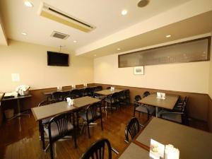 长野筱之井如特酒店的一间带桌椅和电视的用餐室