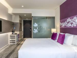 海防海丰美居酒店的卧室配有一张白色大床和紫色墙壁