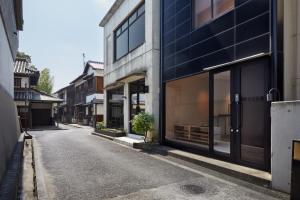 仓敷滔々 御崎 二階の宿 toutou Onzaki Nikai no Yado的一条空的街道,有带窗户的建筑