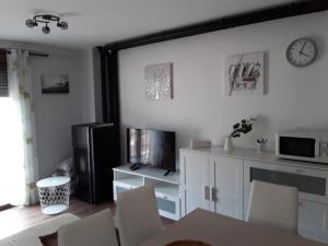 卡马雷纳德拉谢拉Apartamento Las Eras的客厅配有桌椅和微波炉。