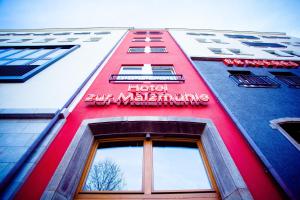科隆玛尔兹穆尔酒店的一面有标志的红色建筑